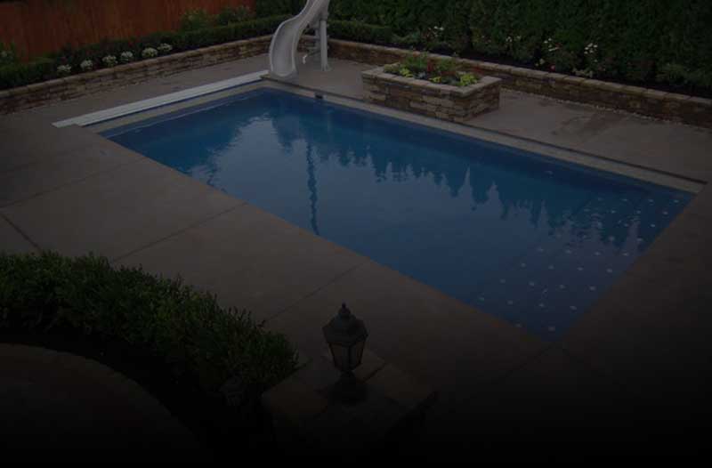 Small rectangular backyard pool with slide